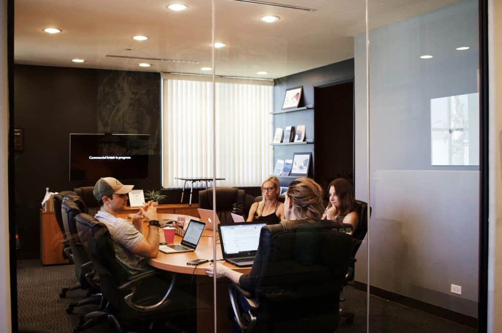 A group of gen-z workers in a conference room meeting