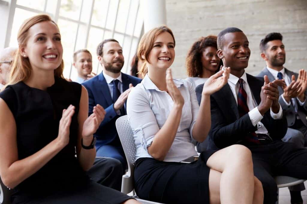 group of people at a business meeting applauding the speaker